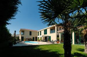 a house with a palm tree in front of it at Villa Marta Luxury House with Heated Pool in Plano