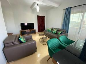 a living room with two couches and a flat screen tv at Human hotel Ivato in Antananarivo