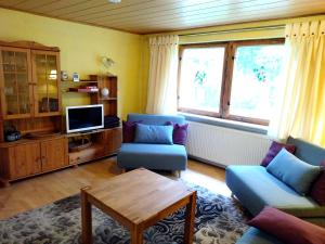 a living room with two chairs and a tv at Ferien am Hegensteinbach in Fürstenberg