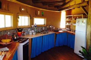 eine Küche mit blauen Schränken und einem weißen Kühlschrank in der Unterkunft Malva Rosa Relax La Juanita in José Ignacio