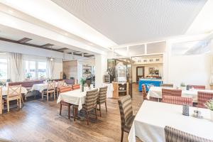 a dining room with white tables and chairs at Chalets am Badesee Lassing in Lassing