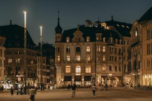 un gran edificio con gente caminando delante de él en Hotel Märthof Basel, en Basilea