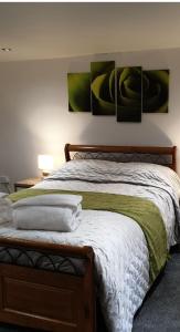una camera con un letto con tre immagini appese al muro di Horseshoe Forge Plover Cottage Lindley a Huddersfield