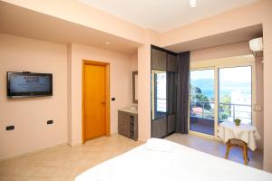 a bedroom with a bed and a tv on a wall at Hotel Aliko in Vlorë