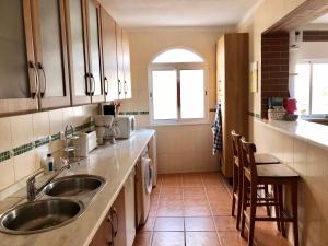 a small kitchen with two sinks and a window at Fuzeta Lovers Apartment in Fuzeta