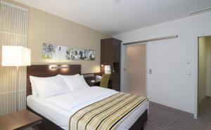 Un pat sau paturi într-o cameră la Holiday Inn Munich Unterhaching, an IHG Hotel