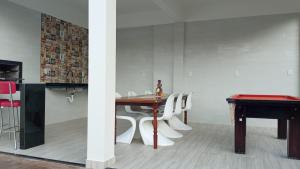 a dining room with a table and white chairs at pousada 3 Marias in Itacaré