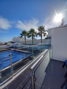 a balcony with a pool and palm trees on a building at Villa Amazing View - S in Albufeira