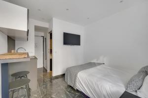 a bedroom with a bed and a kitchen with a counter at Le Bellevue in Paris