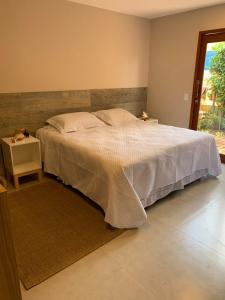 a bedroom with a large bed and a window at Pousada Maresia in Fernando de Noronha