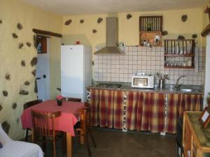 y cocina con encimera, microondas y mesa. en CASA RURAL Vv SATORNO, en Tinguatón
