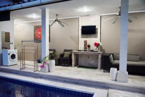 una sala de estar con piscina en una casa en 4 BEDROOM VILLA KUTA REGENCY B10 en Kuta