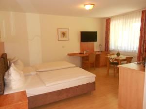 a hotel room with a bed and a desk at Apartment-Pension Schwalbennest in Herzogenaurach