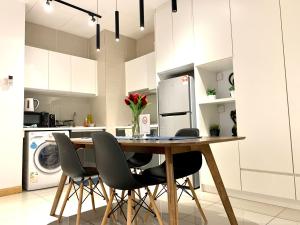 a kitchen with a table with chairs and a refrigerator at KL Gateway Residency in Kuala Lumpur