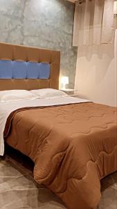 um quarto com uma cama grande e um cobertor castanho em Hotel stranamore em Varcaturo