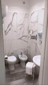 uma casa de banho branca com um WC e um lavatório em Hotel stranamore em Varcaturo