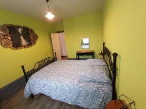 ein Schlafzimmer mit einem Bett in einem Zimmer mit gelben Wänden in der Unterkunft Gite de l'Arbalète in Autun