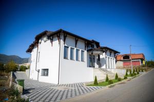 un edificio blanco con techo marrón en una calle en Prenociste ADRIA en Vranje