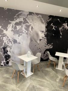 Pokój z dwoma stołami i dużym obrazem kobiety w obiekcie Hotel stranamore w mieście Varcaturo