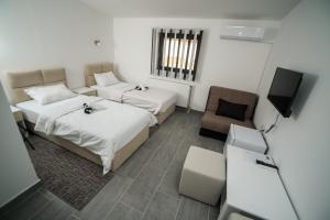 a hotel room with two beds and a television at Prenociste ADRIA in Vranje