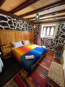 a bedroom with a colorful bed in a room at Riad Atlas 4 Seasons in Imlil