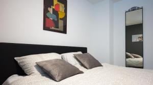 a bedroom with a bed with two pillows and a mirror at Logies De Witte Hoeve in Oudenaarde