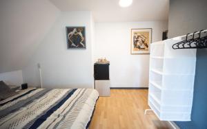 a bedroom with a bed and a white shelf at Logies De Witte Hoeve in Oudenaarde
