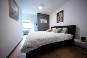 a bedroom with a bed with a black headboard at Logies De Witte Hoeve in Oudenaarde +6 photos