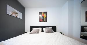 a bedroom with a white bed with two pillows at Logies De Witte Hoeve in Oudenaarde