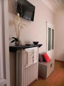 een woonkamer met een radiator en een tv aan de muur bij Palazzo Gropallo Rooms in Genua