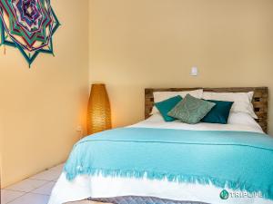 um quarto com uma cama com lençóis azuis e brancos em Chalés da Libélula em Ilhabela