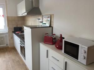 a kitchen with a counter with a microwave and a tv at Ferienwohnung Mimi Souterrainwohnung in Kastellaun