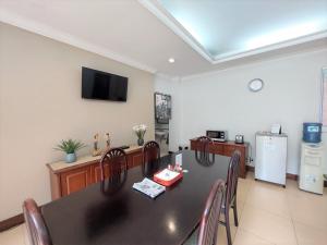 a dining room with a black table and chairs at Via Renata Prapanca in Jakarta
