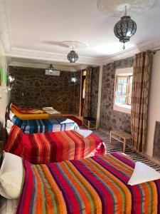 two beds in a room with colorful blankets at Riad Atlas 4 Seasons in Imlil