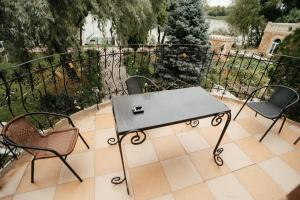 d'une table et de chaises sur un balcon avec une clôture. dans l'établissement Baza Otdiha Zamok, à Khmelëvka