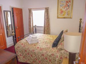 Schlafzimmer mit einem Bett und einem Fenster in der Unterkunft 3 Primitive Mews in Chelmorton