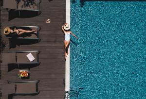 a woman standing in the water next to a swimming pool at Marvie Hotel & Health in Split