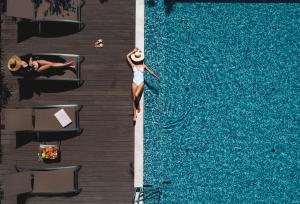 una donna in piedi in acqua accanto a una piscina di Marvie Hotel & Health a Spalato (Split)