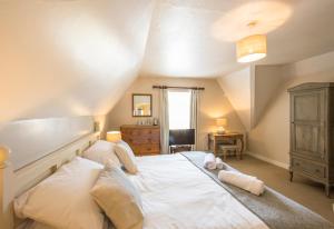 a bedroom with a large white bed and a desk at The Fox Inn in Ansty