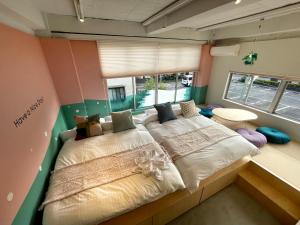 Cama grande en habitación con ventana grande en Hostel Have a Nice Day! ドミトリー 個室ルームあり#HVNI, en Odawara