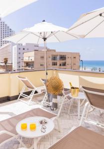 特拉維夫的住宿－Villa Brown Tel-Aviv, a member of Brown Hotels，阳台配有桌椅和遮阳伞。