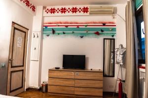 a living room with a tv and a dresser at Hostel Bauhaus in Bucharest