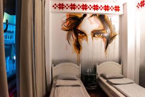 a room with two beds and a painting on the wall at Hostel Bauhaus in Bucharest