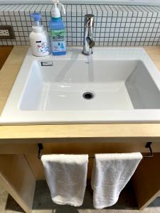 a white sink with two white towels under it at Hostel Have a Nice Day! ドミトリー 個室ルームあり#HVNI in Odawara
