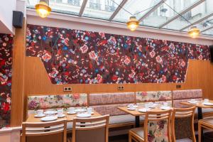 a wall mural in a restaurant with tables and chairs at Maison Axel Opéra in Paris