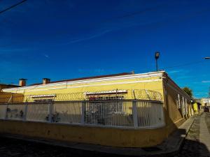 a yellow building with a fence on the side of it at Hotel Muchá in Quetzaltenango