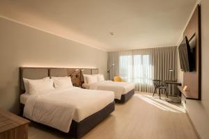 Habitación de hotel con 2 camas y TV en Novotel Santiago Las Condes, en Santiago