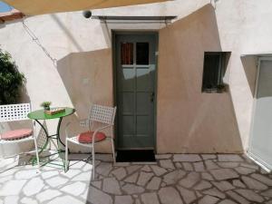 a patio with a table and chairs and a door at Rodomelo Cute Studio 2 in Leonidio