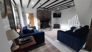 a living room with two blue chairs and a fireplace at Ty Gwyn Hotel in Betws-y-coed