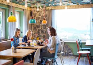 雷騰貝格的住宿－KUKU Berghotel，坐在餐厅桌子上的三个女人